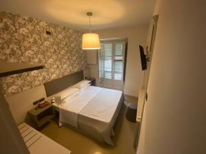 都灵Artua'&Solferino的一间小卧室,配有白色的床和一盏灯