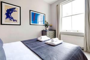 伦敦Contemporary Clapham Living的一间卧室配有一张床,上面有两条毛巾