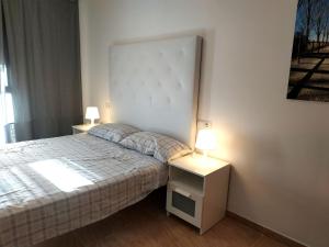 代尔特布雷Mi Apartamento en el Delta del Ebro+的一间卧室配有一张床和两个带灯的床头柜