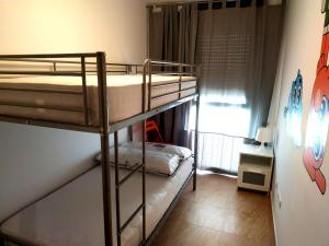 代尔特布雷Mi Apartamento en el Delta del Ebro+的小型客房设有两张双层床和窗户。