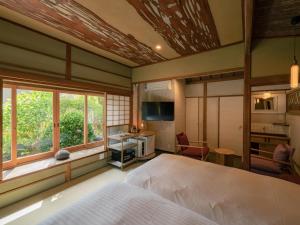 汤河原町巛-sen-湯河原的一间卧室配有一张床、一张书桌和一个窗户。