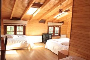 艾德亚耶拉西Ayder Umit Hotel的一间带两张床铺的卧室,位于带木墙的房间内