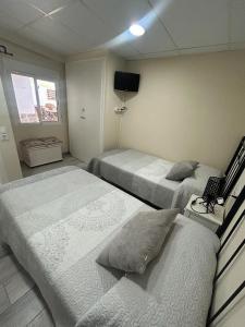 厄尔·波普瑙·德尔·戴尔Cal Music的一间卧室配有两张单人床和一台电视机