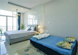 潘切Ocean View Studio,Ocean View 3BR-apartment, Sealinks City, Mui Ne的一间卧室配有两张床和一盏灯。