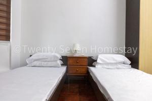 蕉赖Twenty Seven HomeStay的两张带白色枕头的床和梳妆台。