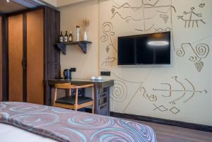 ManaviGiuaani Winery的客房设有1张床、1张办公桌和1台电视。