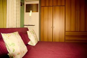 帕蒂Villa Chelia的一间卧室配有带两个枕头的床和橱柜