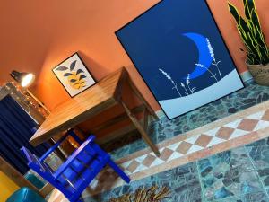 安曼Medusa Home Stay的一张木桌和一张蓝色椅子,靠墙