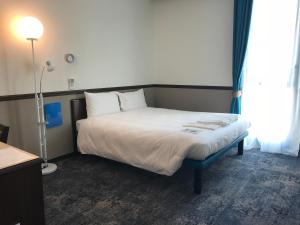 马赛东横马赛圣查尔斯酒店的一间卧室配有床、灯和窗户