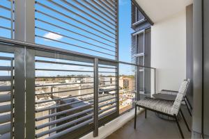 悉尼Broad Land Premium Apartments Chatswood Sydney的阳台配有椅子和书桌。
