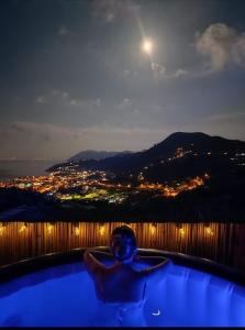 利帕里Casa tra Cielo e Mare的夜间与月亮一起在浴缸里的人