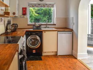 哈雷克Gorwel的厨房配有洗衣机和水槽