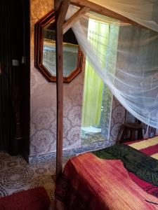 BungomaSasana Motel and Guest House的一间卧室配有一张天蓬床和窗户