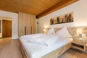 齐勒河谷采尔Hotel Garni Jagdhof的卧室配有白色床和木制天花板