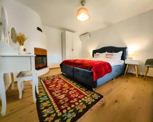 茹里洛夫卡Portita spre Delta的一间卧室配有一张带红色毯子的床和一个壁炉