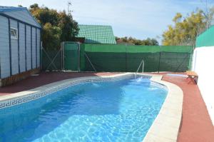贝莱斯Bungalow con piscina en camping privado cerca de la playa de Torre del Mar Ideal familias的后院的游泳池,带围栏