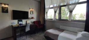 奥普尔扎拉威拉酒店的酒店客房配有一张床、一张书桌和一台电视。