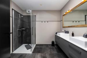 瓦格赖恩Landhaus Rustika的带淋浴、两个盥洗盆和镜子的浴室