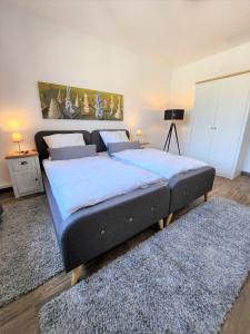 比勒费尔德Art-Appartement的一间卧室配有一张大床,床上铺有蓝色的床单和地毯。
