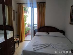 圣金Holiday apartment Shengjin的一间卧室设有一张床,并有通往阳台的门