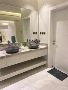 艾卜哈جناح فندقي في فله خاصة的带大镜子的浴室内的2个盥洗盆