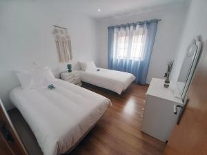 Casais de São MamedeCasa da Avo dos Anjos的酒店客房设有两张床和窗户。