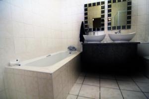 阿尔伯顿Fuhri Road Apartments Madison House的浴室配有两个盥洗盆和浴缸。