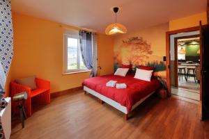 热拉梅Granit'Home的一间带红色床的卧室和一间用餐室