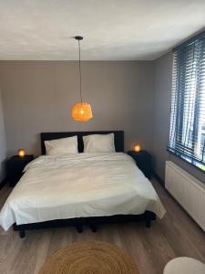 赞丹Casa Xabia的卧室配有一张白色大床和吊灯。
