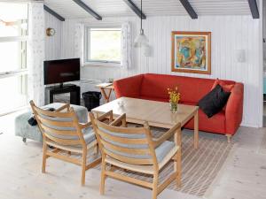 瓦伊厄斯斯特兰德6 person holiday home in Vejers Strand的客厅配有红色的沙发和桌子