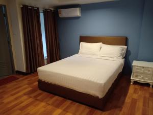 清迈Airport A1 Hotel的一间卧室配有一张带白色床单和蓝色墙壁的床。