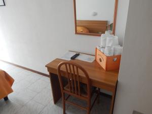洛阿诺HOTEL MILANO的一张桌子、一把椅子和一盒卫生纸