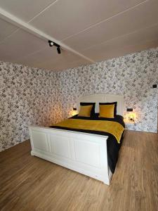 胡法利兹Ferme La Joye的卧室配有一张带黄色枕头的大型白色床。