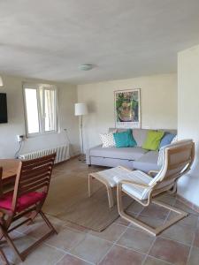 马洛塞讷Petit Paradis的客厅配有沙发和两把椅子