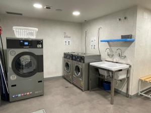 蓬费拉达Guiana Rooms - Adults Only的洗衣房配有2台洗衣机和水槽
