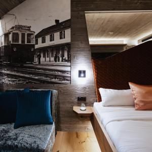 萨尔茨堡附近奥伯恩多夫Hotel Gleiserei的一间卧室,配有一张床,火车在轨道上