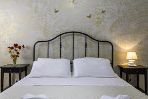 拉卡莱La Gemma del Salento的一间卧室配有一张带白色床单的床和两张桌子