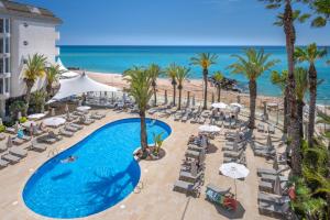圣苏珊娜Caprici Beach Hotel & Spa的享有度假胜地的空中景致,设有游泳池和海滩