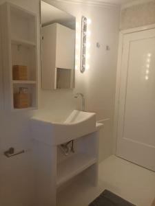 TagaradesCozy house的白色的浴室设有水槽和镜子