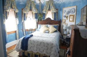 密尔沃基舒斯特之家住宿加早餐旅馆的一间卧室配有一张蓝色墙壁和窗户的床