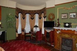 密尔沃基舒斯特之家住宿加早餐旅馆的客厅设有壁炉和电视。