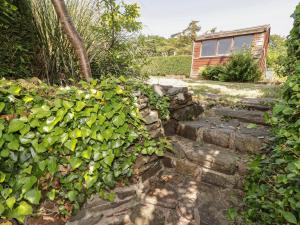 巴里港Daisys Cottage的一座带石墙和房屋的花园
