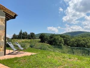 布奇内La Casetta Biricocolo的两把椅子坐在一个享有山景的庭院上
