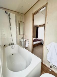 罗切斯特Haven Holiday Home at Kent Coast Allhallows的浴室配有大型白色浴缸和水槽