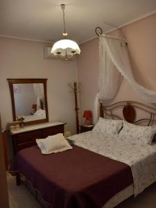 科罗皮Poly's Sea Side House的一间卧室配有一张大床和镜子
