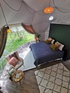斯莱戈Teapot Lane Glamping - Adults only的帐篷内的卧室,配有一张床和椅子