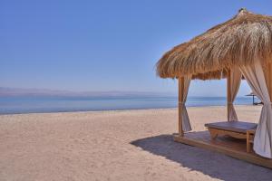 塔巴贝维尤塔巴高地度假村的海滩上的一把草伞和长凳