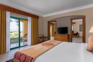 塔巴贝维尤塔巴高地度假村的一间卧室设有一张床,阳台配有电视。