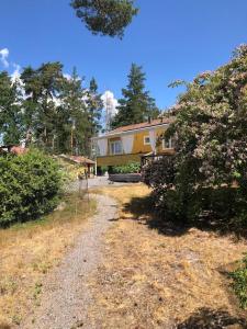 韦姆德Havsnära villa, närhet till stan的前面有一条碎石路的房子
