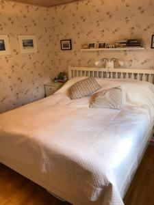 韦姆德Havsnära villa, närhet till stan的卧室内的一张白色床,配有花卉壁纸